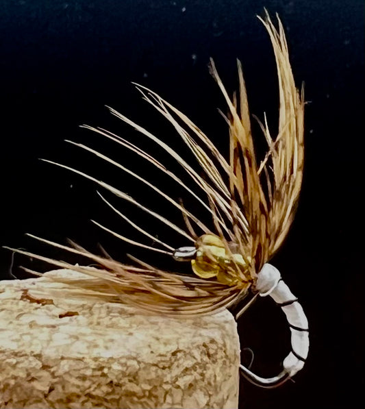 Fishing fly with cork body on a dark background